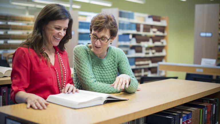 women reading book in law library