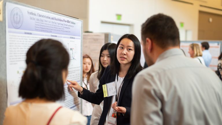 a student presents a poster at the Research & Creativity Showcase