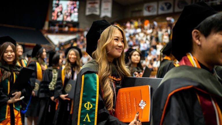 Student graduates in PharmD regalia.