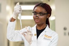 Student wearing lab coat in research lab