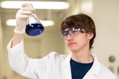 Student wearing lab coat in research lab