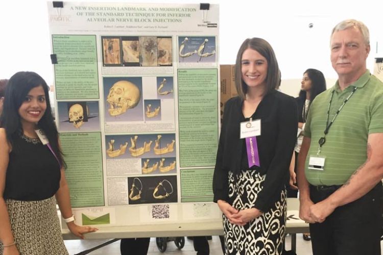 Students Robin Lambert and Riddhima Suri, members of the DDS Class of 2017, along with their faculty advisor Dr. Gary D. Richards, pose with the poster for their project, "A New Insertion Landmark and Modification of the 'Standard Technique' for Inferior Alveolar Nerve Block Injections".