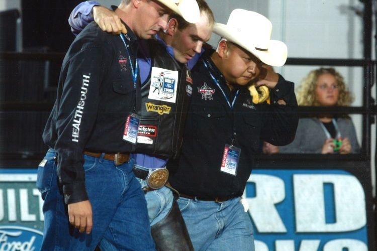 Peter Wang (far right) helps an athlete at a Professional Bull Riders event.