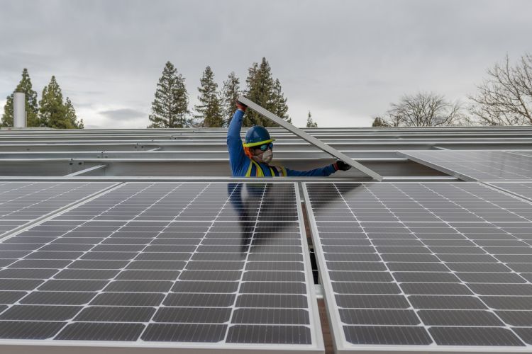 A worker installs a solar panel on Pacific's campus