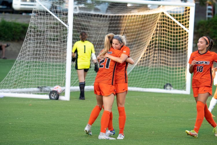 two soccer plays hug on the field