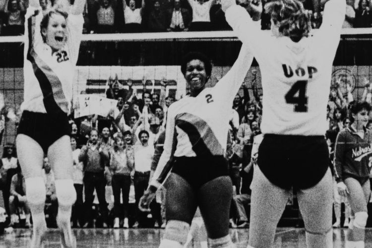 Volleyball players celebrate a win on the court