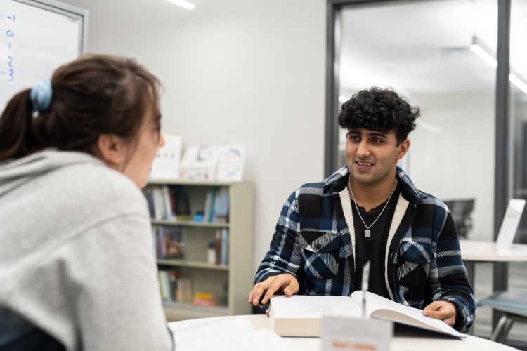 two students sitting at a table in the tutoring center