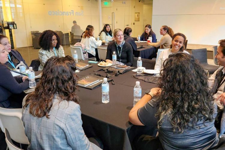 students sit at a table inside Bloomberg offices