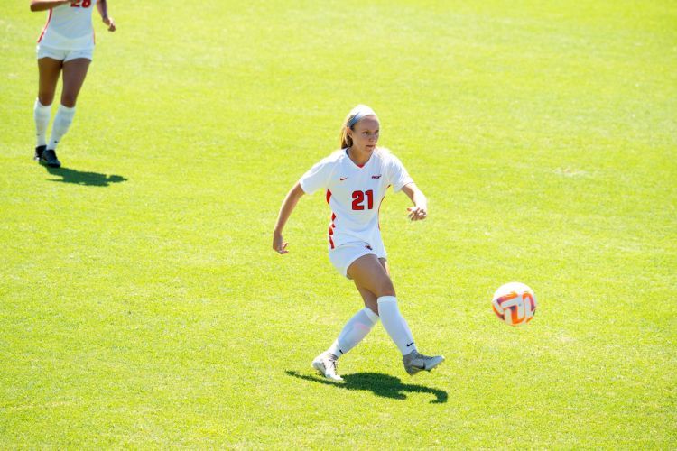 Abigail Wolf kicks the ball on a soccer field