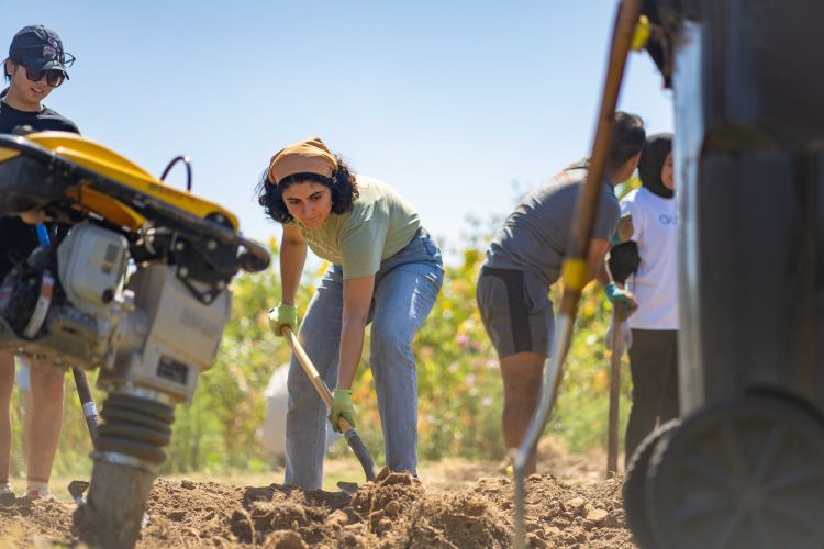 a student digs dirt during the day of service