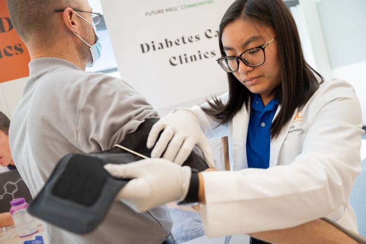 a student works with a patient at a diabetes care clinic