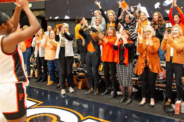 women cheer on the women's basketball team