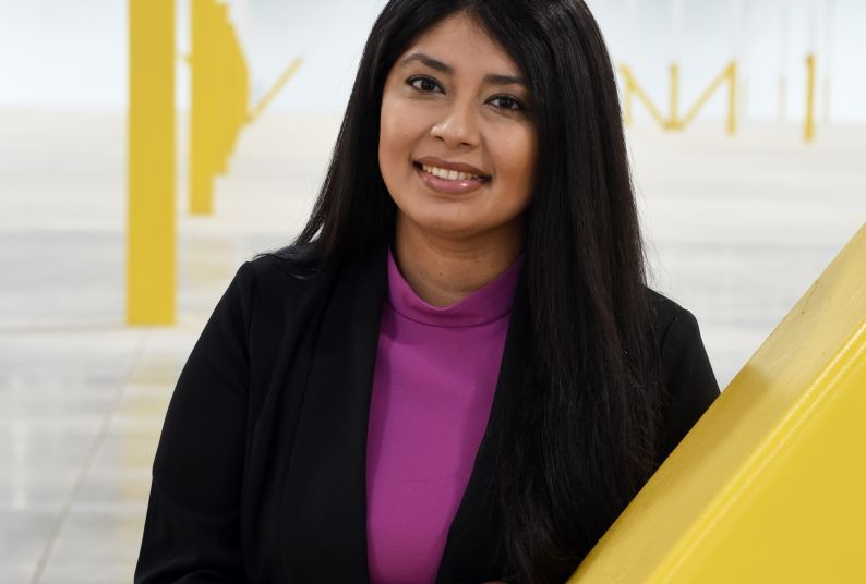 A portrait of Mariana Corona Sabeniano in front of a yellow and white backdrop