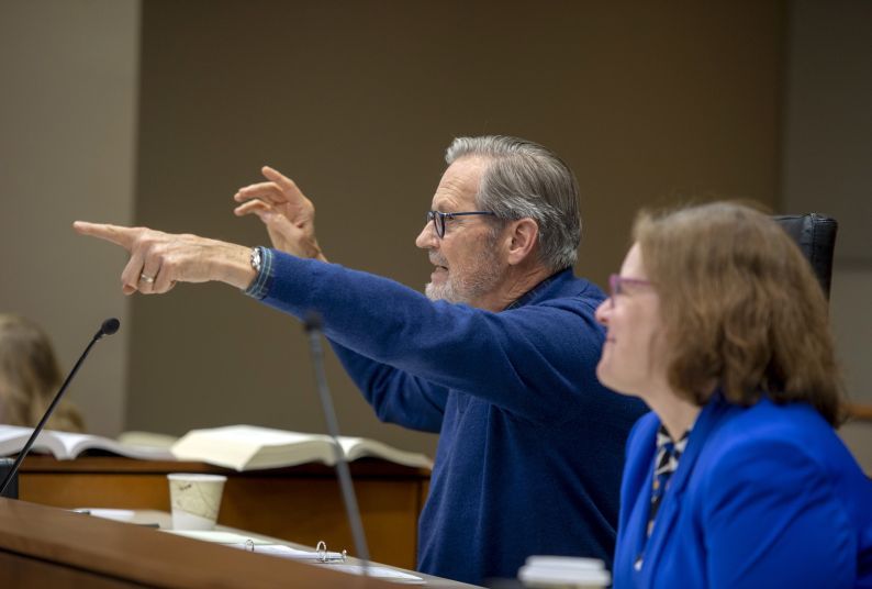 A man points in a courtroom