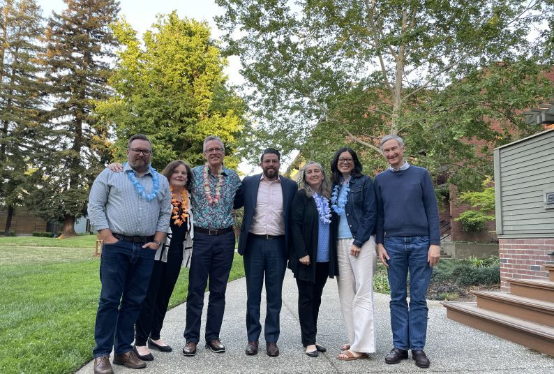 A picture of seven people pose outside for a photo