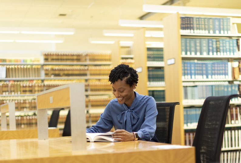 a student sits at a desk in the law library