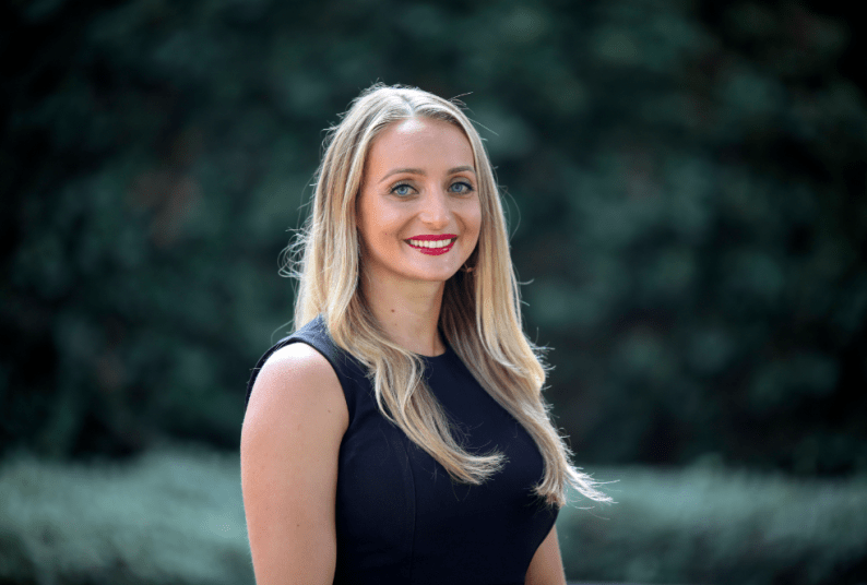 woman in black shirt smiles for a headshot 