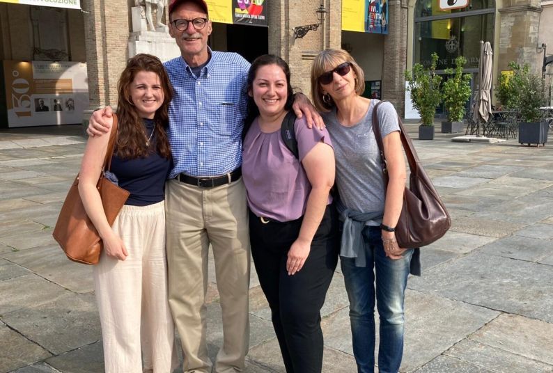 A group of four people pose for a photo in Italy