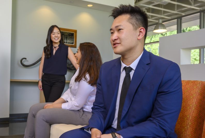 Three PharmD students in the student lounge in the Chan Family Health Sciences Learning Center and Clinics