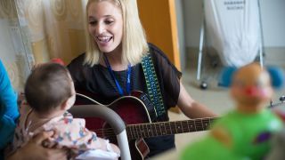 University of the Pacific MA in Music Therapy student Kathleen Humphries works with young patient during field visit.