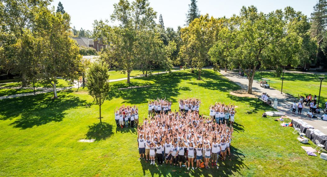 Students standing together in paw print formation