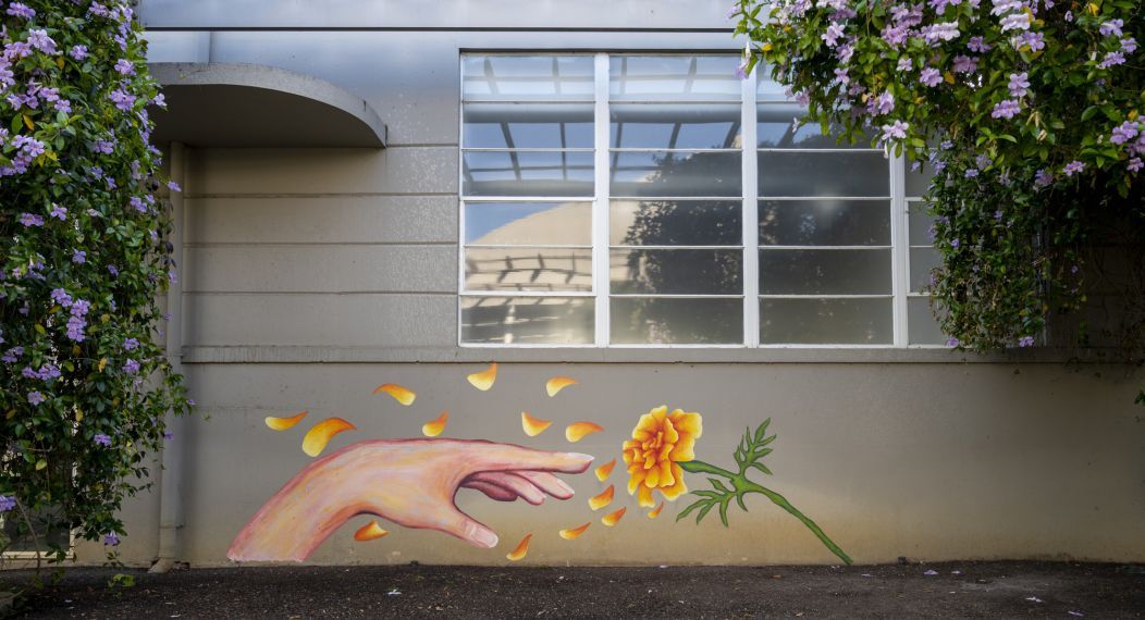 art mural of hand reaching a flower