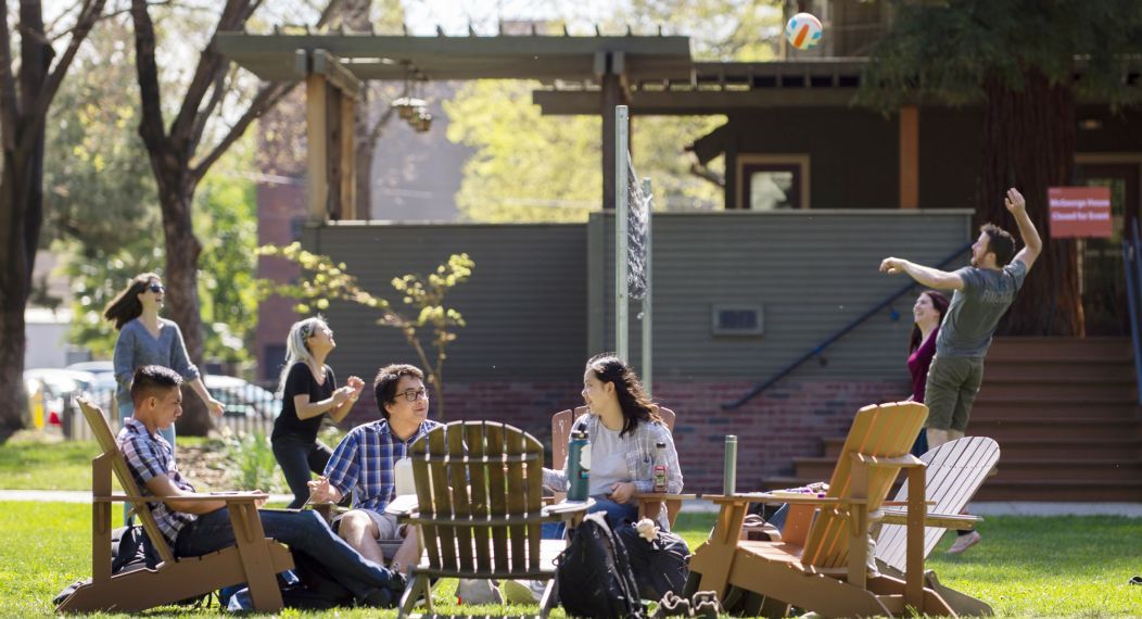 students relax outside on the lawn on the Sacramento campus