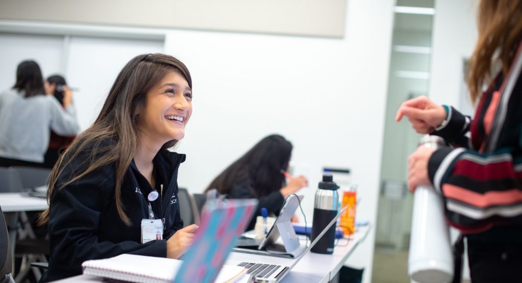 students smiling at desk