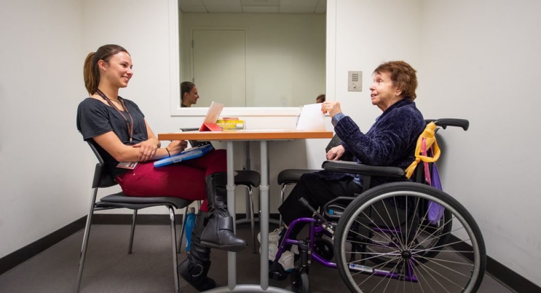 student talking to woman in wheelchair