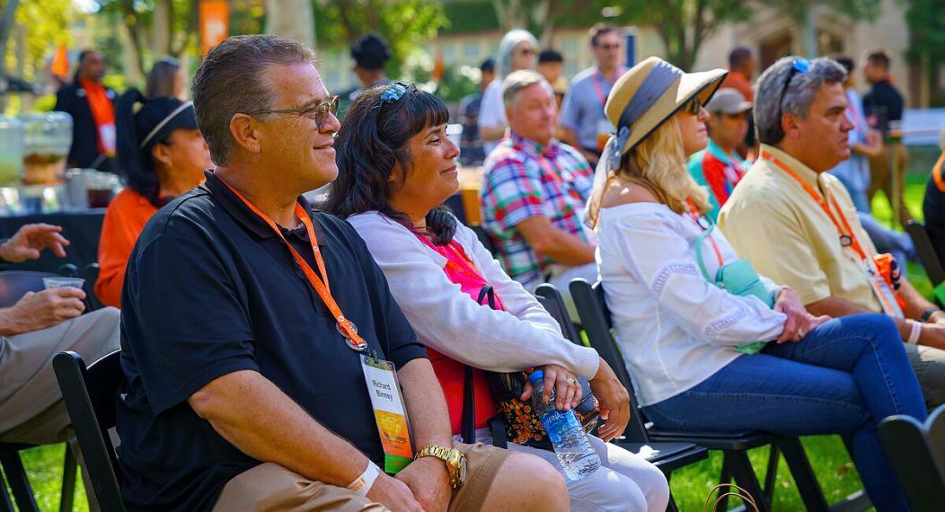 alumni listen to a presentation outdoors