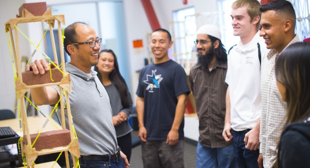 A professor talking with students in a lab.