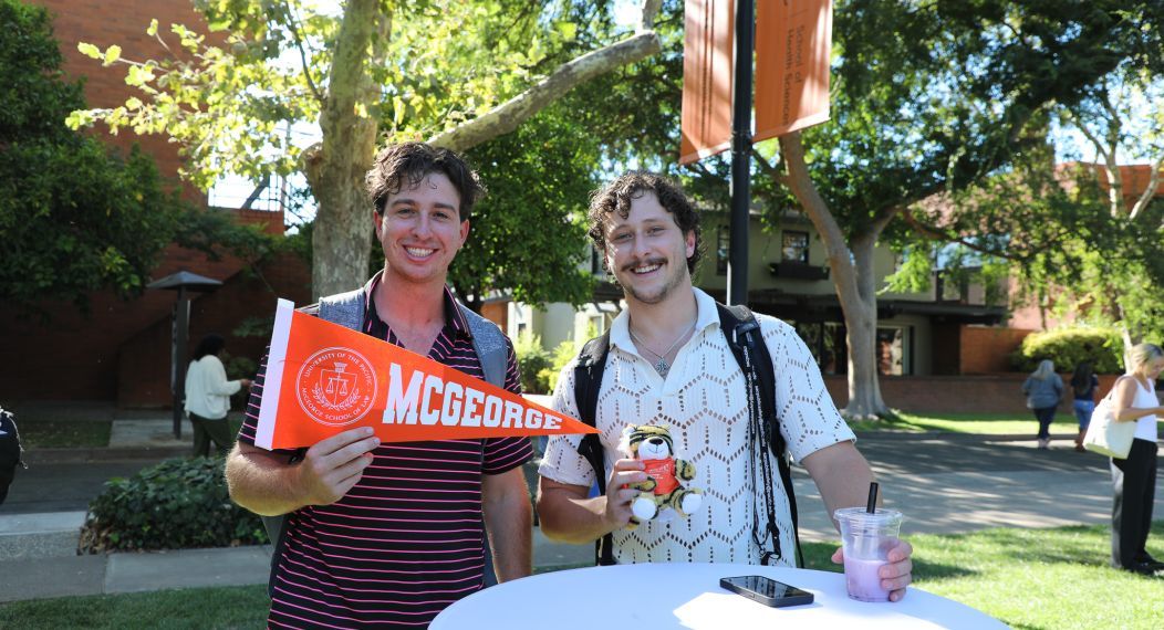 two students holding a sign that says McGeorge