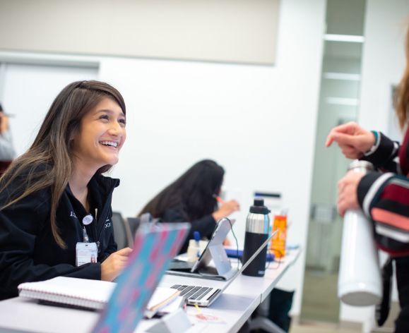 students smiling at desk