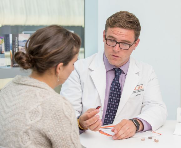 Audiology student holding hearing aids