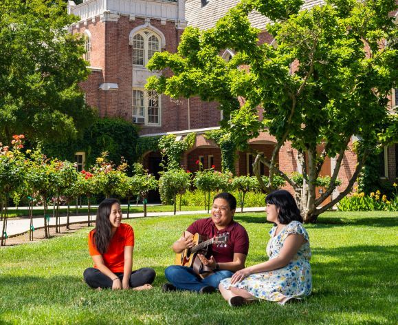 students sitting on lawn next to Morris Chapel