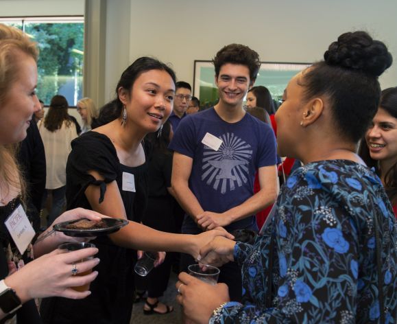 students shaking hands at event