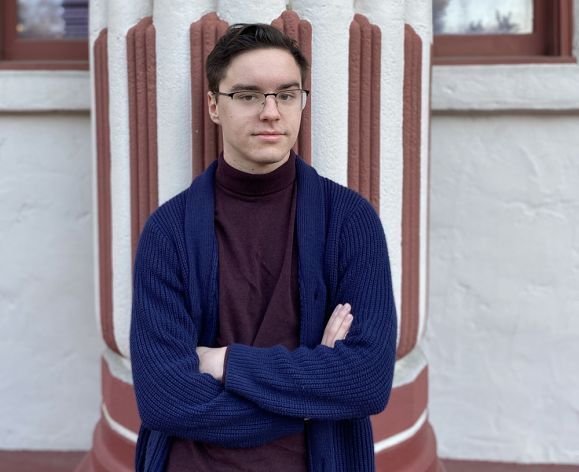 A college student standing outside by a building