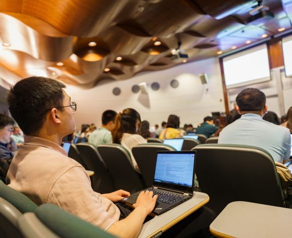 Student with laptop in a lecture classroom.