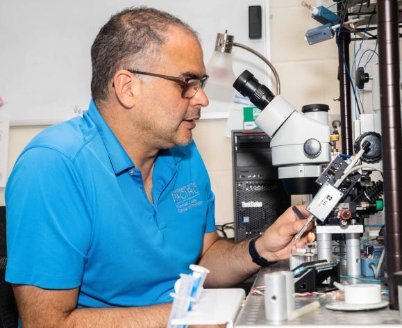 Professor looking through a microscope.