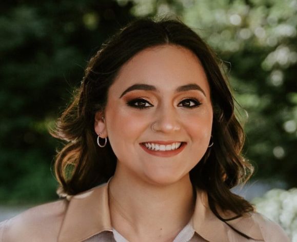 A portrait of a woman wearing a button down shirt 