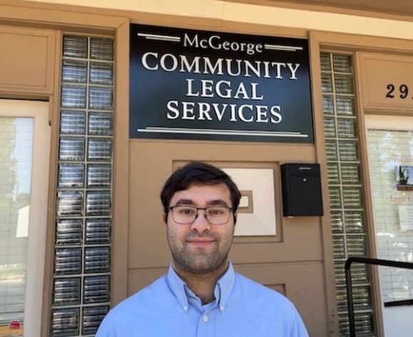 A man poses for a photo outside of a building