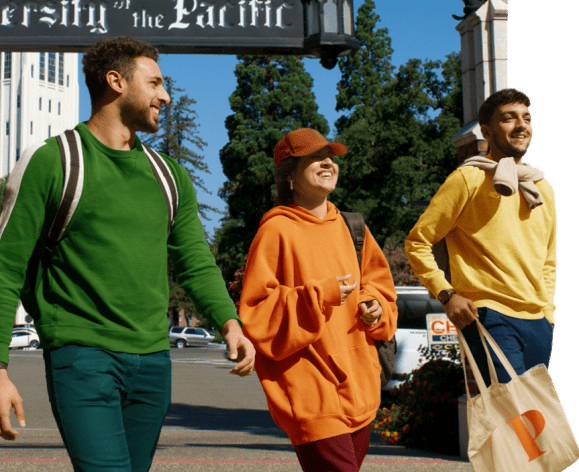 students walk in front of the university of the pacific sign