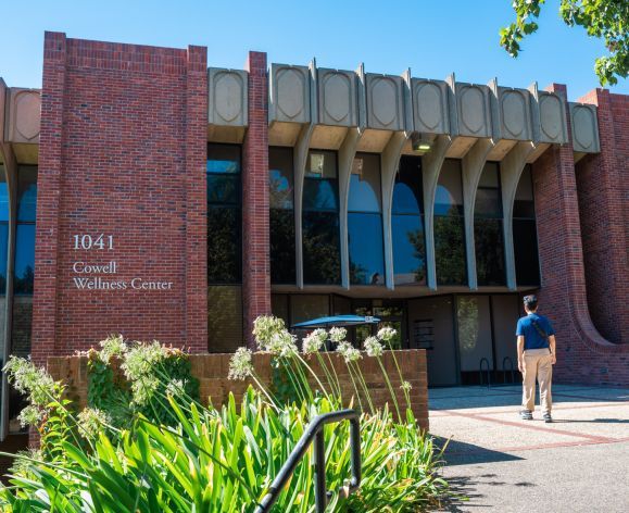 Image of a student walking towards the Cowell Wellness Center