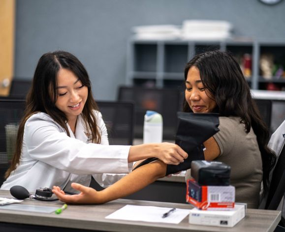 Health Ed. student taking the blood pressure of another health ed. student.