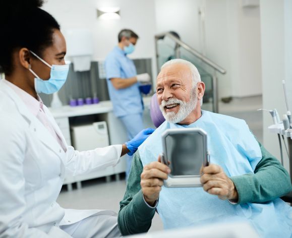 smiling older man with beard talking to dentist