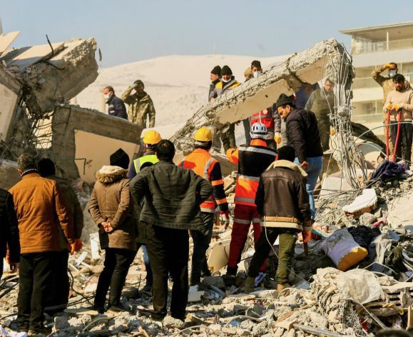 Image shows a team of responders working on saving earthquake victims from a building.