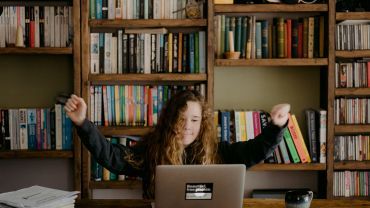 student in front of laptop in library area